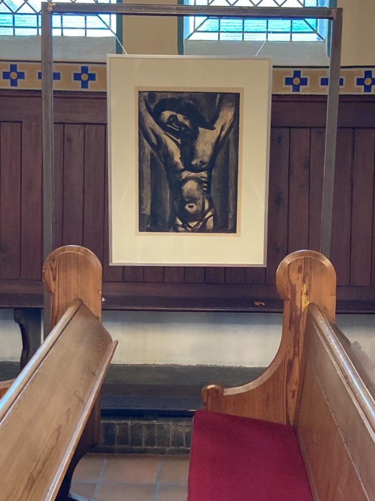 Ein Gemälde von einer Kreuzigung in einer Kirche, umgeben von Holzinterieur.