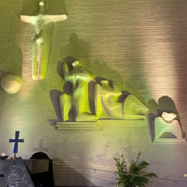Künstlerische Darstellung eines Kreuzes und stilisierter Figuren in sanften Lichttönen.