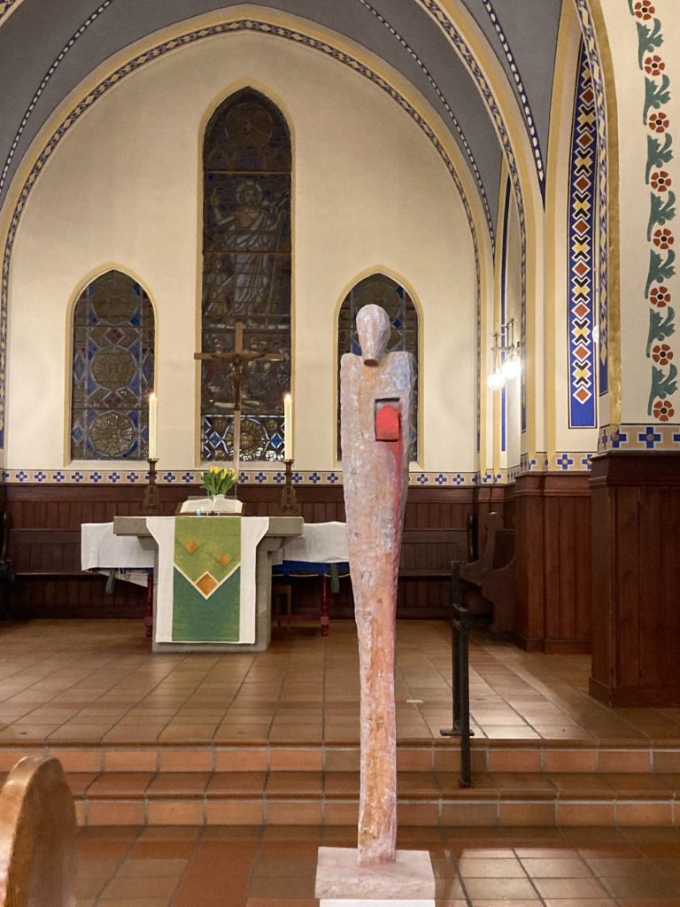 Ein Gemälde von einer Kreuzigung in einer Kirche, umgeben von Holzinterieur.