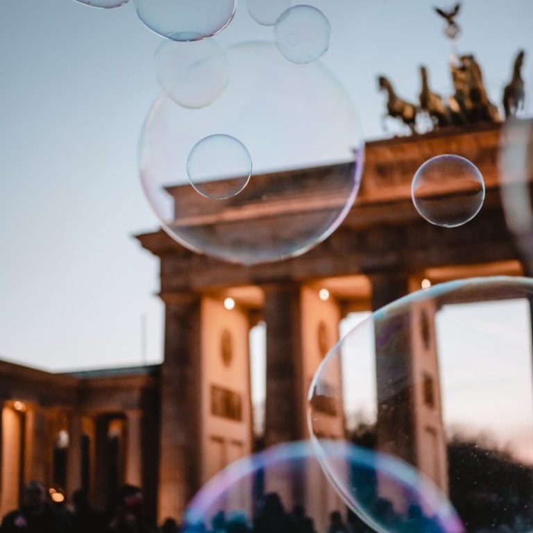 Das Brandenburger Tor mit Seifenblasen im Vordergrund bei Dämmerlicht.
