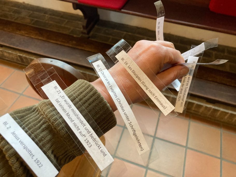 Ein Handgelenk mit mehreren Zetteln, die kurze Texte oder Notizen tragen.